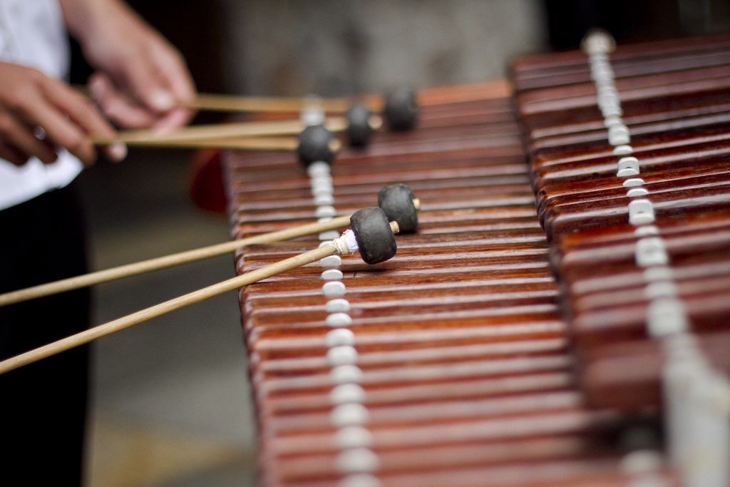 Traditional Honduran musicians playing marimba, guitars and percussion instruments in colorful traditional clothing at a cultural festival